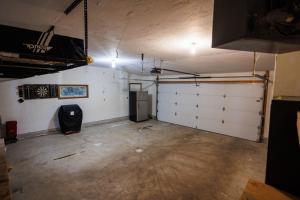 eine leere Garage mit weißen Türen und einem Kühlschrank in der Unterkunft Marina Cottage by Simple Life Rentals in Baileys Harbor + 17 Fotos