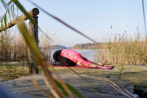 a person is laying on a dock near the water at Gut Groß Zecher - Ferienzimmer in Seedorf