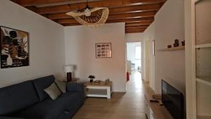 a living room with a blue couch and a television at Esperança House 2 in Maia