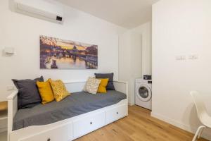 Camera bianca con letto e cuscini gialli di Little House 15 a Roma