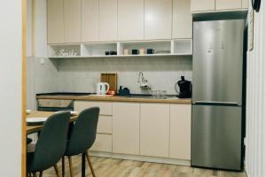 una cucina con frigorifero e tavolo con sedie di CENTRaL FLaT a Sombor
