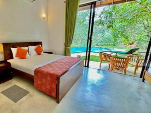 a bedroom with a bed and a patio with a table at Aqua Dunhinda Villa in Kandy +73 photos