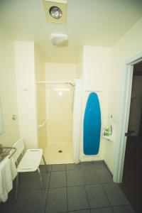 a bathroom with a shower with a blue surfboard at The Chalet Motel in Mequon