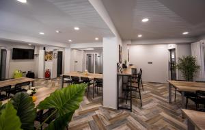 een eetkamer met tafels en stoelen en een televisie bij DORM BG pet-friendly Aparthotel in Stara Zagora