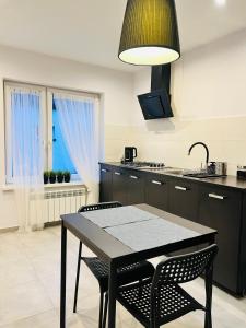 a kitchen with a table and chairs and a kitchen with a window at Różana City Apartaments in Kutno
