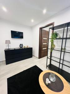 a living room with a table and a tv at Różana City Apartaments in Kutno