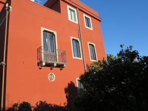 a orange building with a balcony on the side of it at Villa Astoria in Taormina