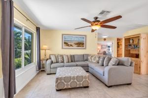 Una sala de estar con un sofá y un ventilador de techo. en Heated Pool & Spa Home on a Scenic, Gulf Access Canal -Close to Bonita Beach!, en Bonita Springs