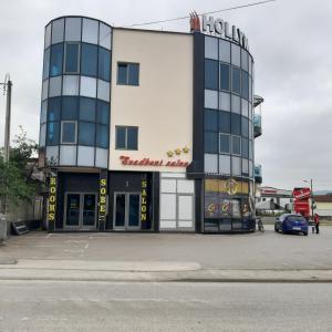 a building with a car parked in front of it at Hollywood Motel in Podlugovi