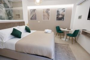 a bedroom with a large bed and two green chairs at Dimora in Cortile in Manfredonia