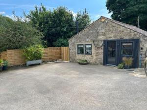 a stone house with a fence in front of it at Richmond Hill Cottage Markington in Ingerthorpe