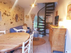 a living room with a wooden table and a staircase at Gîte du Clos Giot in Saint-Vaast-la-Hougue