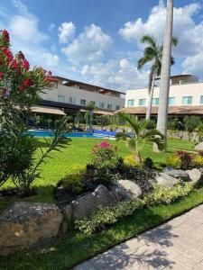 a resort with a garden with flowers and a pool at Casa Cumbres Tulipanes Descanso Americano in Chiconcuac