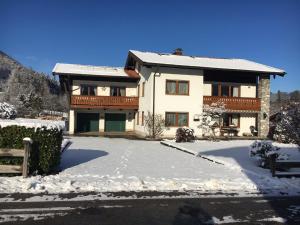 a large house with snow on the ground at Ferienwohnung Deininger inkl. Chiemgaukarte in Ruhpolding +6 photos