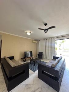 a living room with two couches and a television at Casa Mar Arraial d'Ajuda in Arraial d'Ajuda
