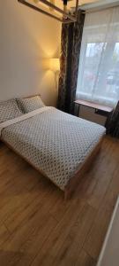 a bed in a room with a wooden floor at Apartament z ogrodem in Lublin
