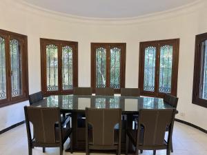 a dining room with a table and chairs and windows at Villa familiale Achakkar 2 in Tangier +31 photos