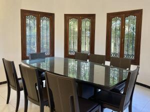 a dining room with a glass table and chairs at Villa familiale Achakkar 2 in Tangier