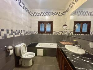 a bathroom with a toilet and a sink and a tub at Villa familiale Achakkar 2 in Tangier