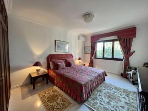 a bedroom with a bed and a table and a window at Villa familiale Achakkar 2 in Tangier