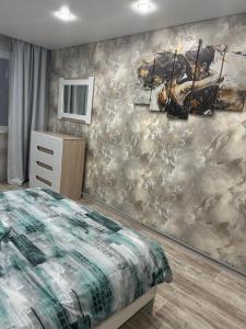a bedroom with a painting on the wall at Двухкомнатная уютная квартира in Ekibastuz +3 photos
