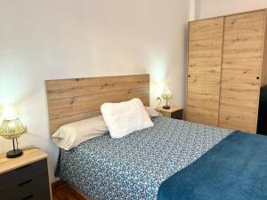 1 dormitorio con 1 cama, 2 mesitas de noche y 2 lámparas en Apartament de muntanya amb una terrassa espectacular by RURAL D'ÀNEU, en Valencia de Aneu