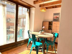 Un comedor con mesa y sillas y una ventana. en Apartament de muntanya amb una terrassa espectacular by RURAL D'ÀNEU, en Valencia de Aneu