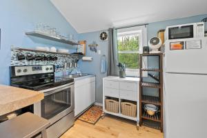 a kitchen with a stove and a refrigerator at Sunset Shores - Sunflower Cabin #4 by Simple Life Rentals in Baileys Harbor