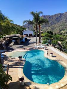 una piscina en un patio con montañas al fondo en Casa Rural Caserío Las Viñas, en Guájar Fondón