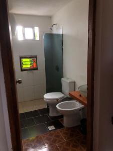 a bathroom with a toilet and a sink at Las Alqui millas Apart in Punta Del Diablo +8 photos