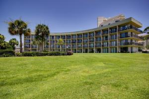 Un gran edificio con césped delante. en Pirates Bay A204, en Fort Walton Beach
