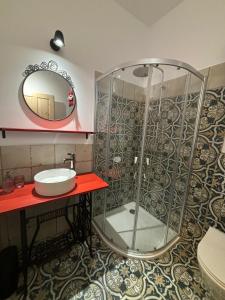 a bathroom with a shower with a sink and a mirror at Pastelowa Czantoria in Ustroń