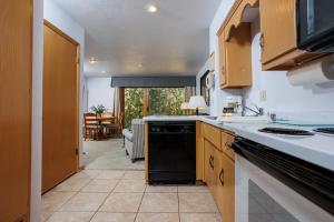 a kitchen with a black dishwasher next to a living room at Hilltop View in Fish Creek Unit B-3 by Simple Life Rentals in Fish Creek +18 photos