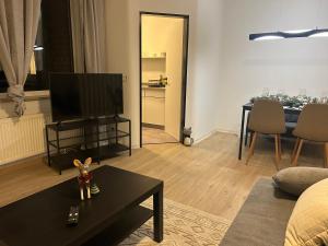 a living room with a tv and a table at Station Suite in Delmenhorst