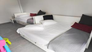 een slaapkamer met 2 bedden met witte lakens en rode kussens bij Hanioti Beach Front Apartments in Hanioti