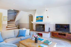 een woonkamer met een bank en een open haard bij Villa Beauregard by Villa Plus in Tourrettes