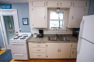 una cocina con armarios blancos y un horno de fogón blanco en Latitude Adjustment by Simple Life Rentals, en Jacksonport