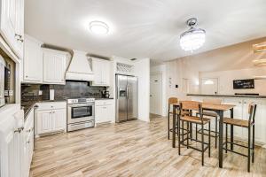 a kitchen with white cabinets and a table and bar stools at Convenient, Spacious and Peaceful Home in Edinburg! in Edinburg