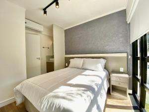 a bedroom with a large white bed and a window at Loft dos sonhos em Canela in Canela
