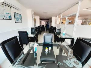 a conference room with a glass table and black chairs at Karin Hotel in Ríohacha