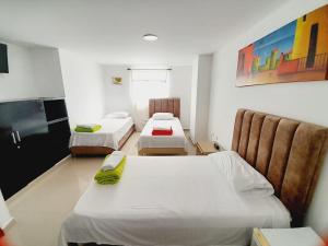 a room with three beds and chairs in it at Karin Hotel in Ríohacha +37 photos