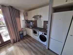 cocina pequeña con nevera y fogones en Studio chaleureux avec piscine, en Le Barcarès
