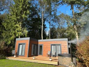 a tiny house on a deck with a trash can at Kempings Jaunzāģeri "Pietura" in Sigulda