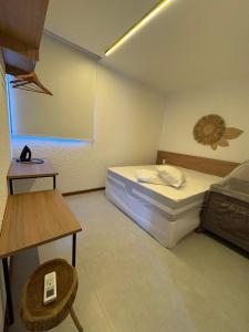 a small room with a bed and a table at VILLAS M PATACHO - Aluga Apto F001 in Pôrto de Pedras