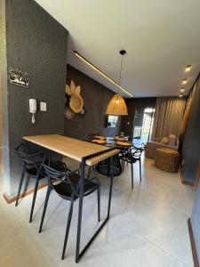 a dining room and living room with a table and chairs at VILLAS M PATACHO - Aluga Apto F001 in Pôrto de Pedras