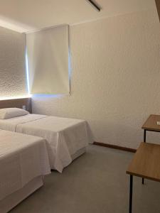 a hotel room with two beds and a window at VILLAS M PATACHO - Aluga Apto F001 in Pôrto de Pedras
