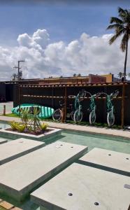 two bikes are parked next to a swimming pool at VILLAS M PATACHO - Aluga Apto F001 in Pôrto de Pedras +14 photos