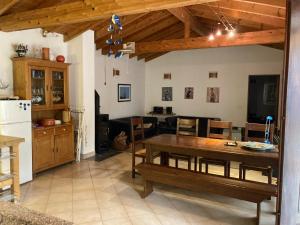 a kitchen and living room with a wooden table and a dining room at Oleiro de Cima in São Teotónio