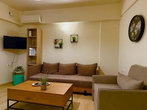 a living room with a couch and a table at Central Studio Semi-basement in Heraklio