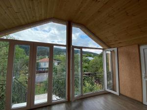 een lege kamer met een groot glazen raam bij Surami Comfort House in Surami +12 foto's